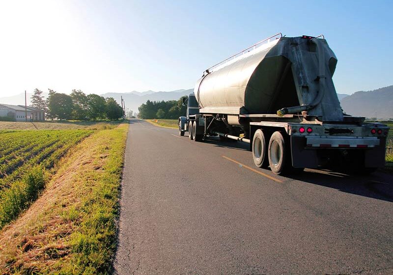 dairy truck driving down farm country road