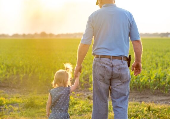 farmer walking hand in hand with child